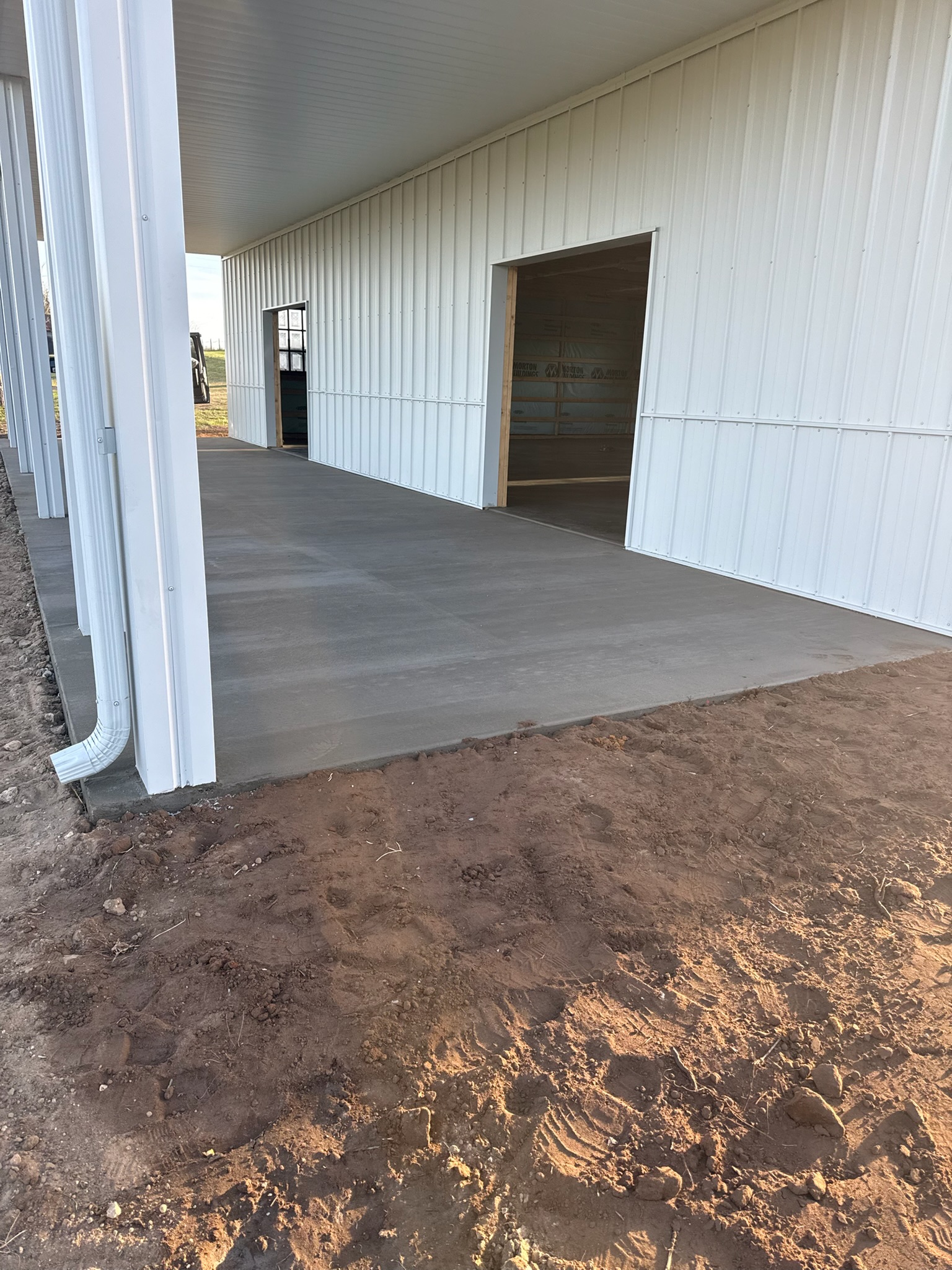 Finished sidewalk pour area with tools and cleanup around the new concrete