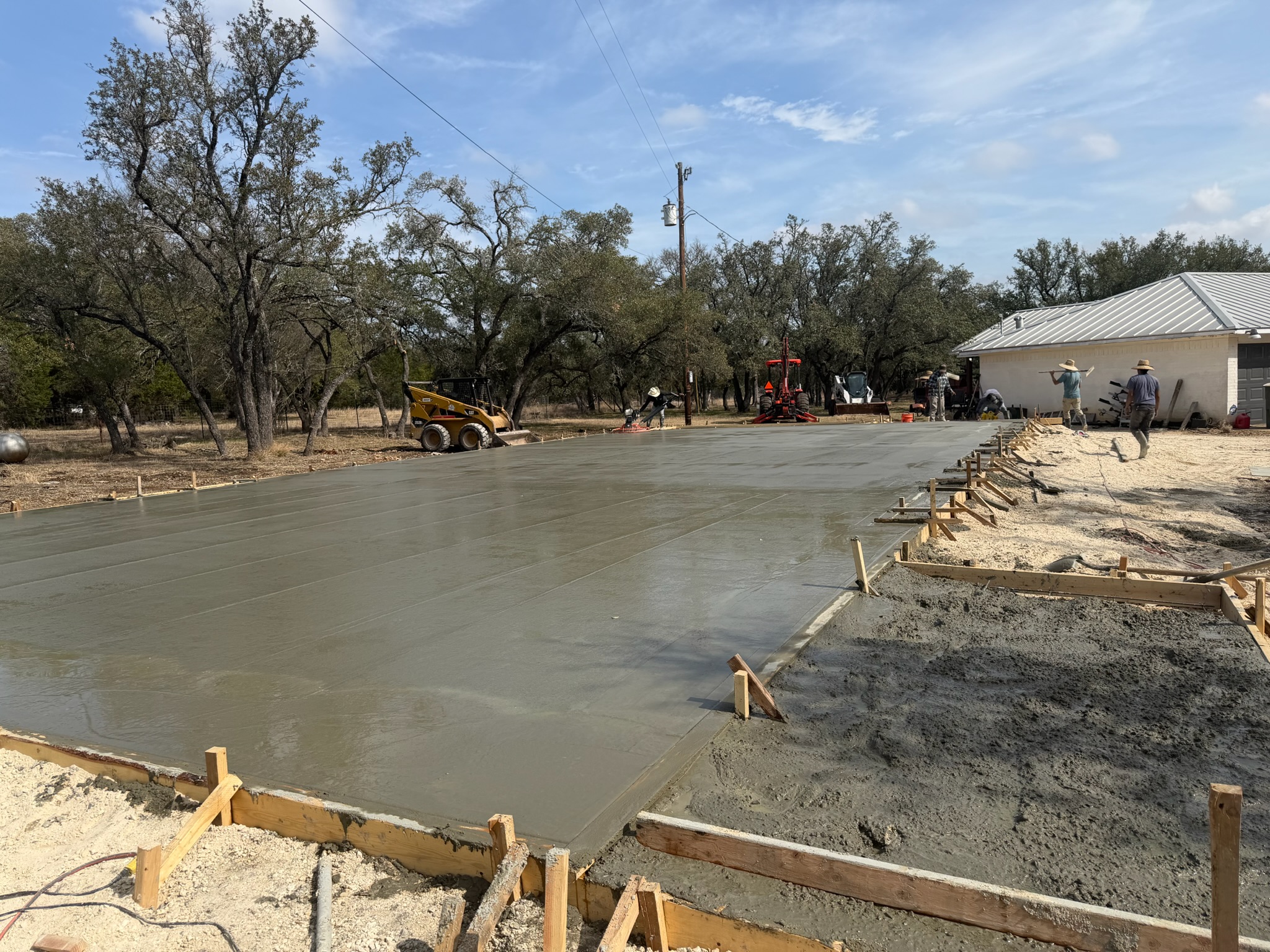 Fresh concrete shop foundation slab being finished in Georgetown, TX