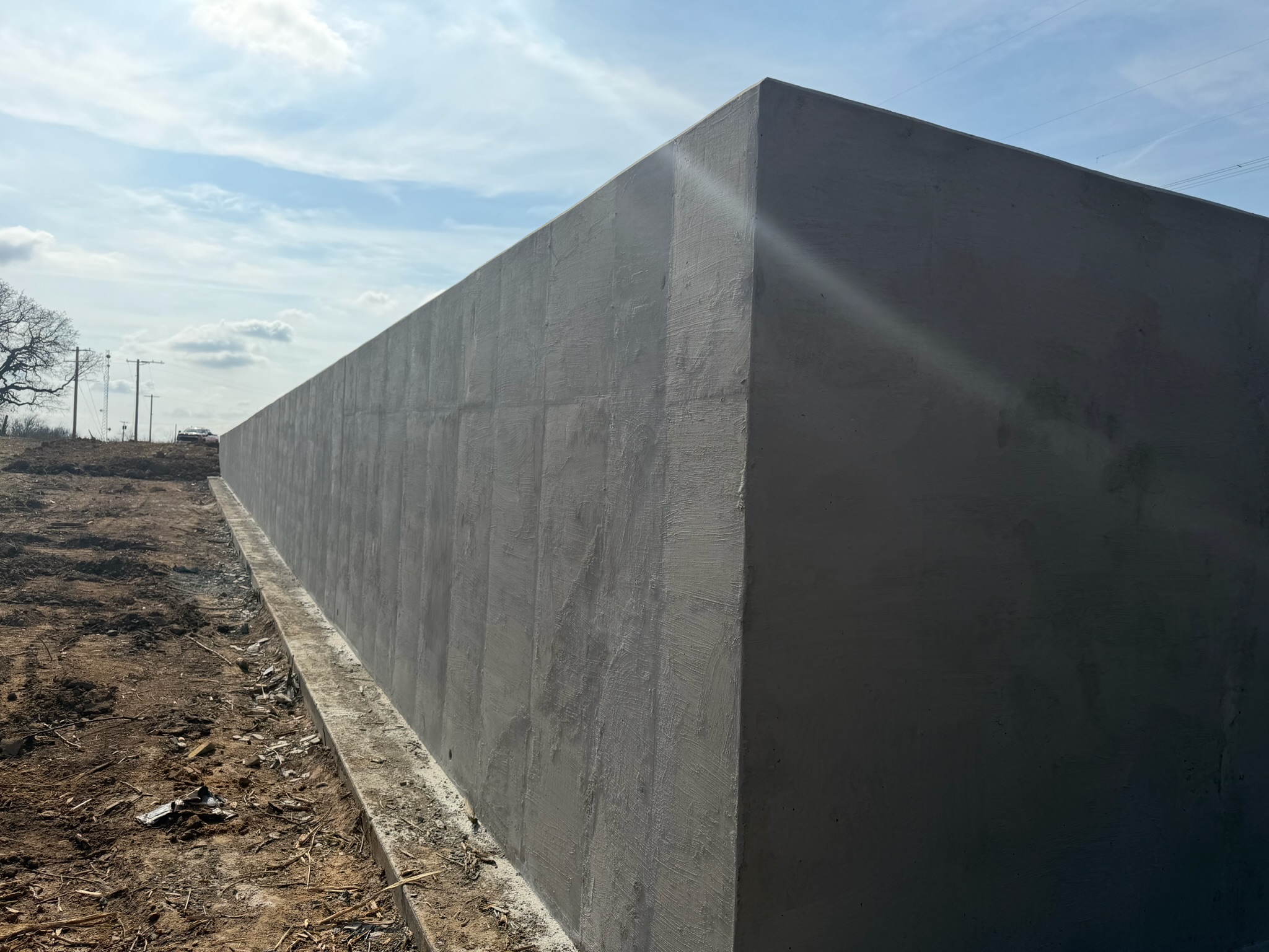 Finished section of concrete retaining wall and cleared jobsite access in Georgetown