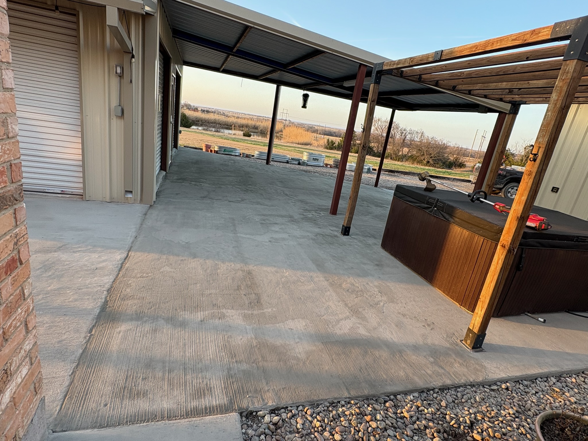 Resurfaced patio concrete under a covered outdoor area beside a shop