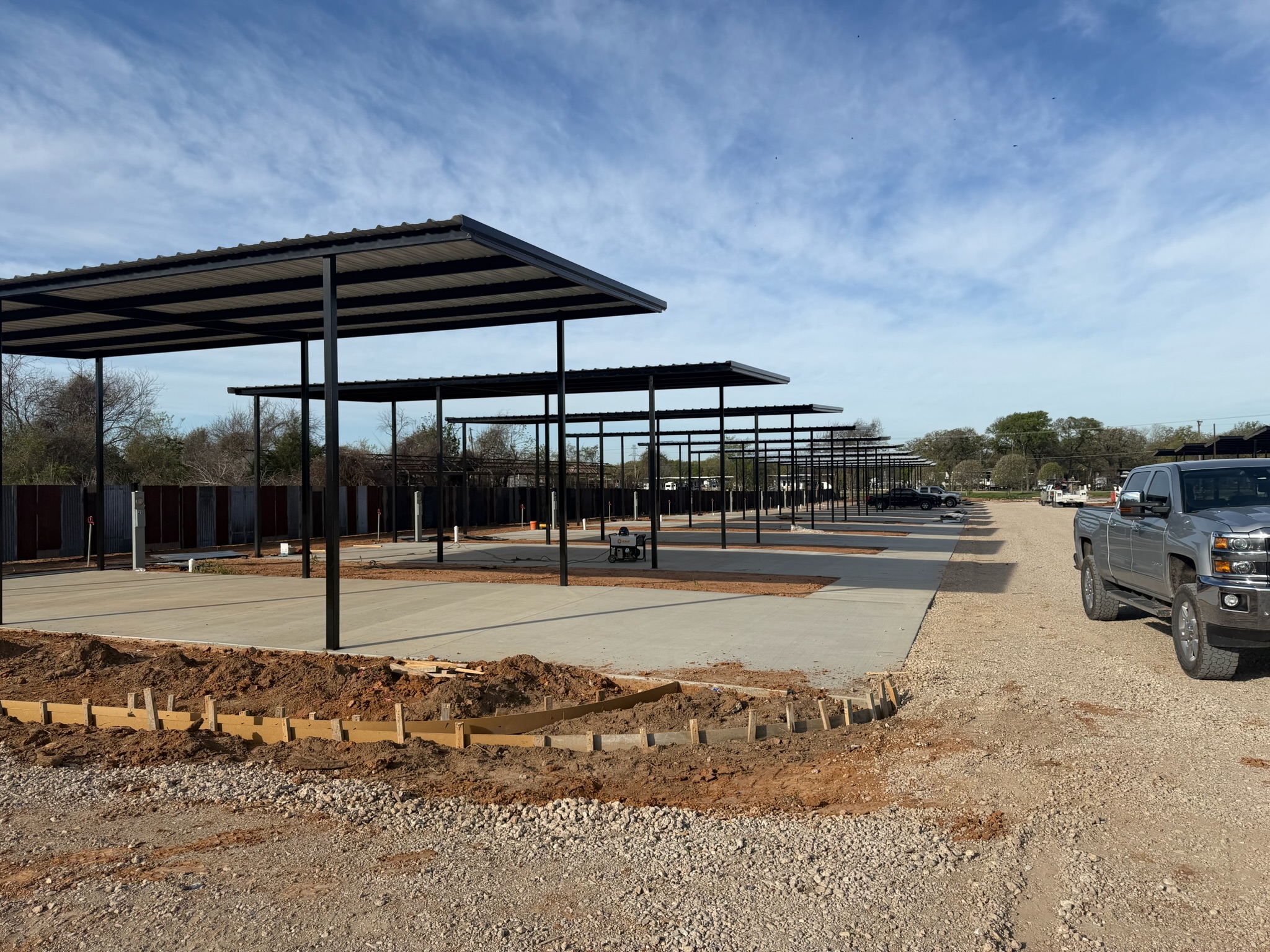 Long row of covered RV parking pads with new concrete flatwork in Waco