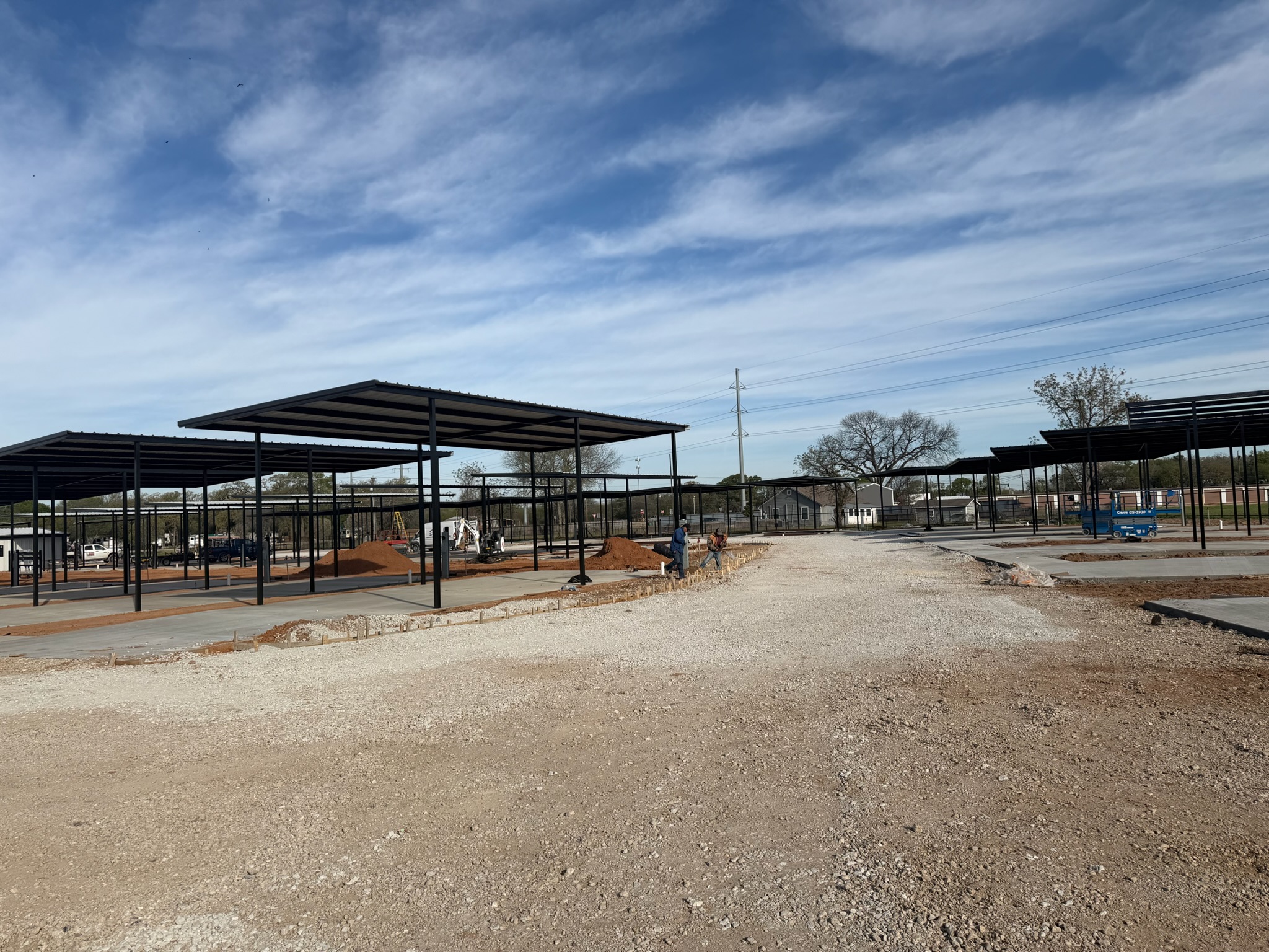 Magnolia RV concrete pads, gravel access, and covered structures under construction