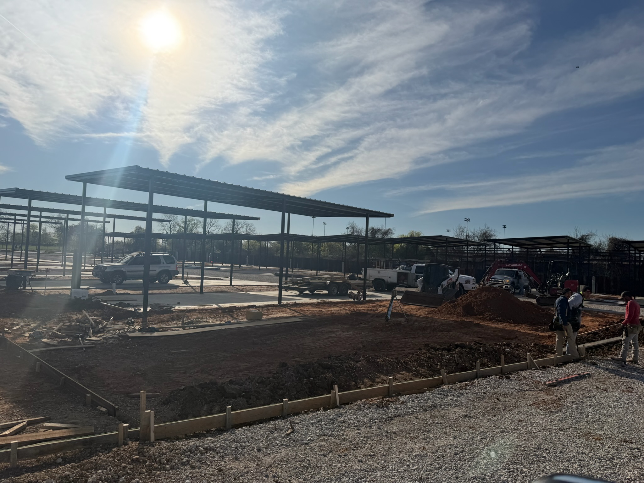 Concrete crew and equipment working around new Magnolia RV pad forms