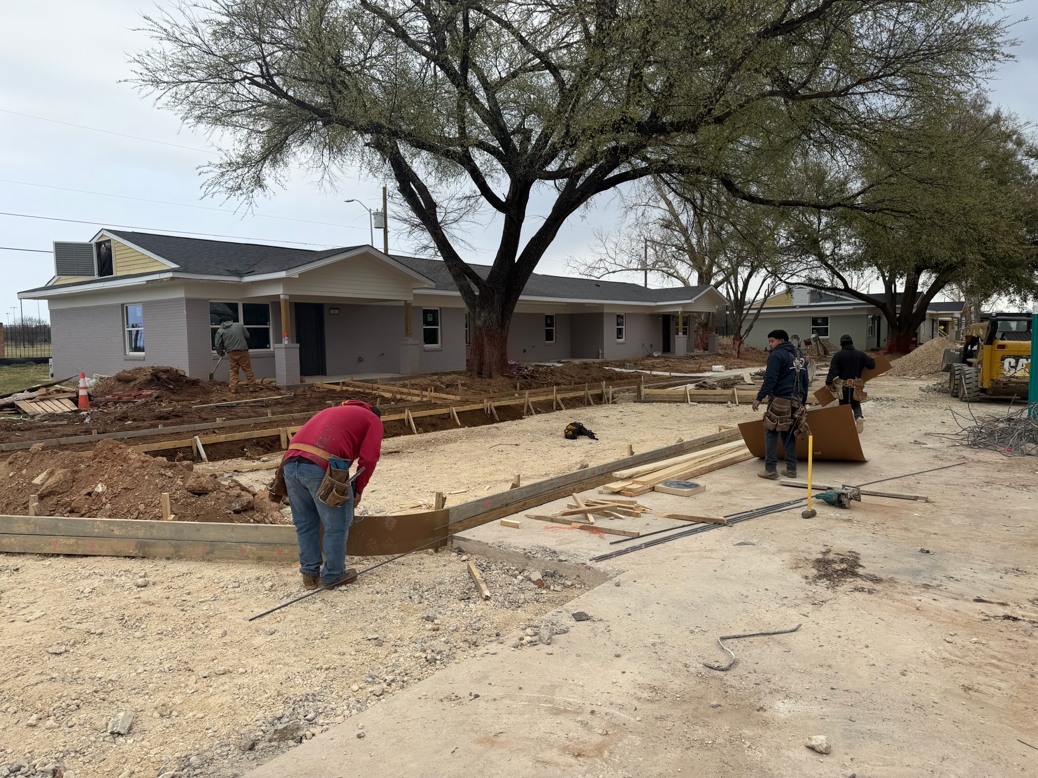 Concrete crew setting forms for handicap parking work at Melody Grove in Waco, TX