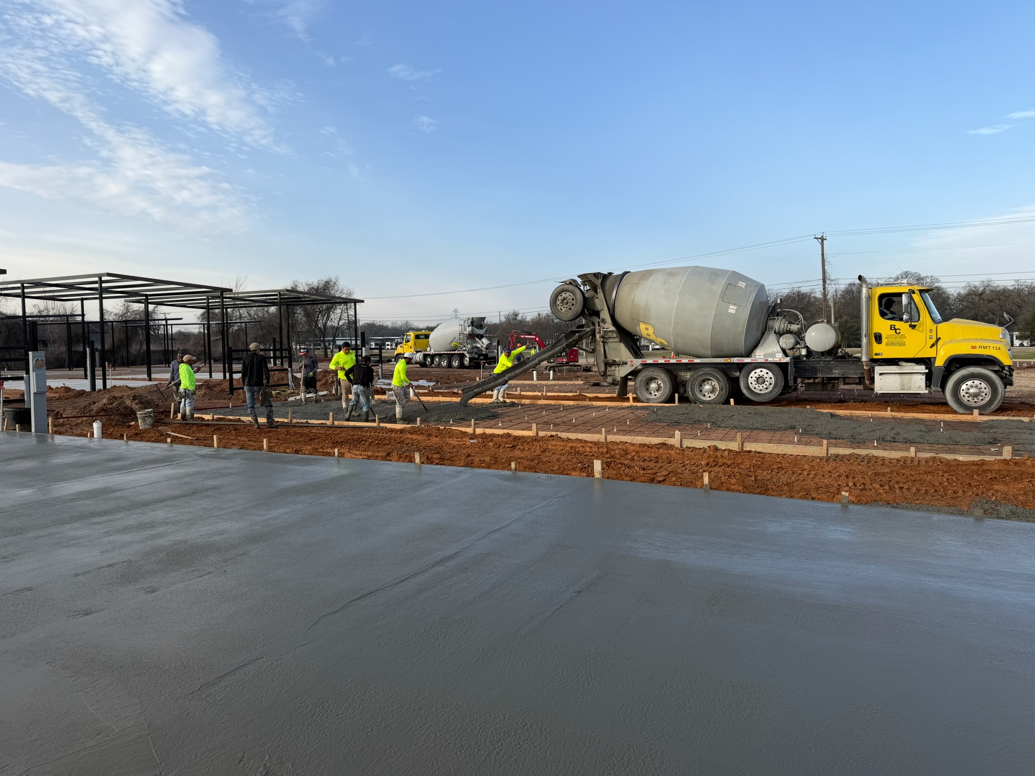 Concrete crew placing fresh parking area flatwork at Melody Grove