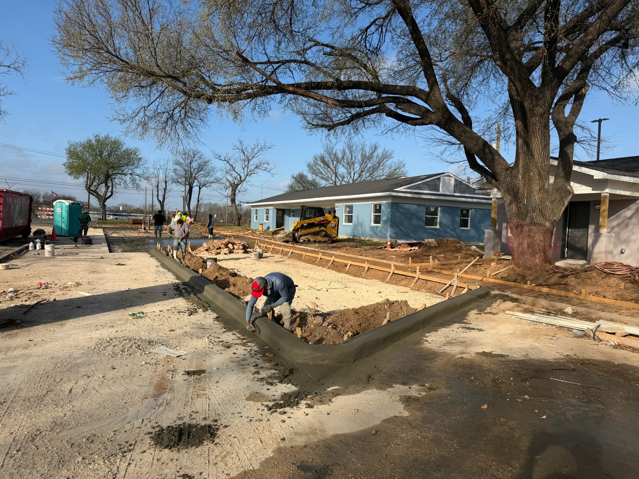Crew finishing concrete edges and curb at Melody Grove in Waco